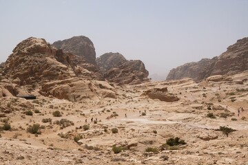 Fototapeta premium Wonderful mountain views with silhouettes of hiking people on the Jordan Trail from Little Petra (Siq al-Barid) to Petra. Jordan, Hashemite Kingdom of Jordan 