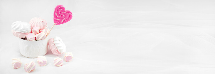 Candies and sweets on a white background. Lollipop heart and love. Sweets are harmful to teeth and dental treatment