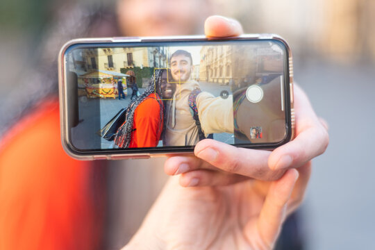 Happy multiethnic couple in the city taking photo - Smiling man and african girl taking selfie with smartphone on street – multiracial Happy couple having fun and taking a selfie – mixed race smiling 