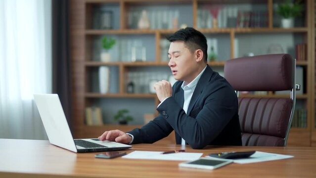 Evil angry asiasn boss business man talking angrily online on video call remotely with subordinates. Businessman arguing and shouting at a conference meeting using a laptop computer in the office