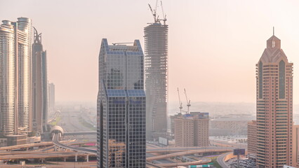 Dubai city skyline panoramic view with metro and cars moving on city's busiest highway aerial timelapse