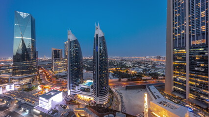 Aerial view of Dubai International Financial District with many skyscrapers day to night timelapse.