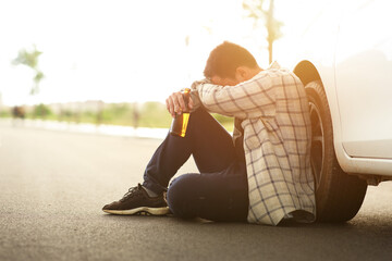 Drunk man sleeping with a car on the roadside, campaigning for drunken not driving avoiding...