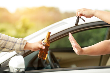Man with car key refusing glass of beer from his friend and say no for safety, campaigning for drunken not driving avoiding accidents on road, Don't drink and drive concept.