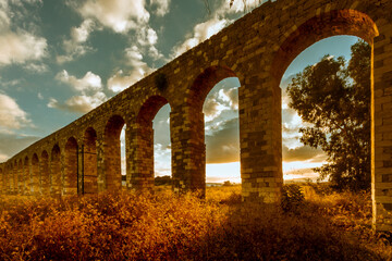 Fototapeta na wymiar A Roman aqueduct at sunrise in Kibbutz Lohamei Haghetaot