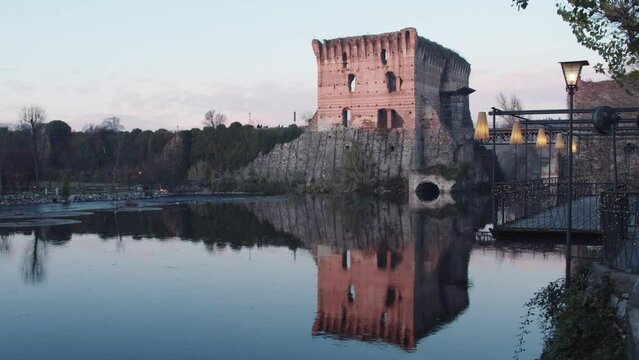 Borghetto. Famous Italian village in Valeggio sul Mincio, near Lake Garda. People and cars cross the Long Bridge between the ancient medieval fortifications. Tourism in wintertime.