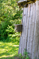 wooden barn with a wooden bird cage attached to the wall.