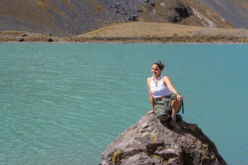 Blond woman sitting on a stone in the snowy Ausangate, by Yuri Ugarte Cespedes.