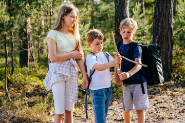 A little boy with a concentrated emotion on face and a bow with an arrow in his hands, older...