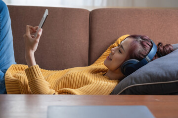 relax, de-stress, holiday, happy, Asian woman relaxing at home listening to music from smartphone and laptop happily.