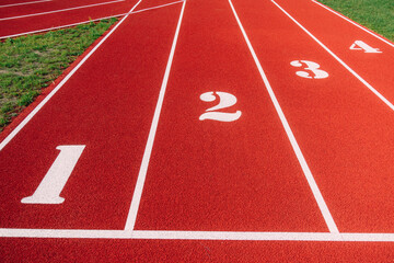 Sports stadium with red running tracks lines with numbers on it - obrazy, fototapety, plakaty