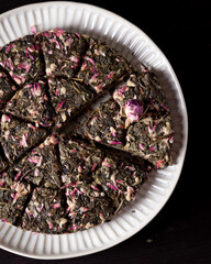 pressed leaf green tea with rose bud on the plate