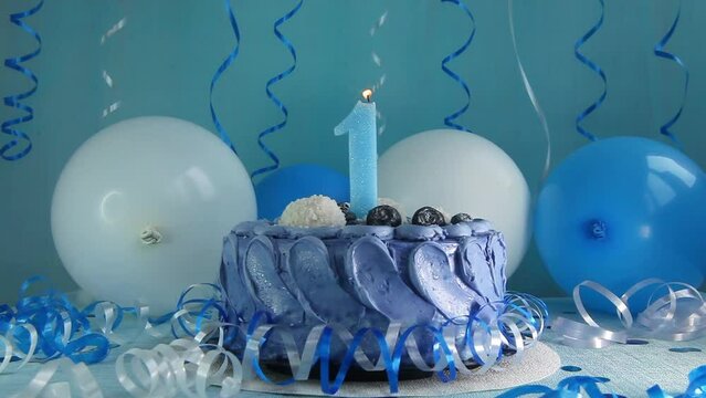 Happy first birthday navy cake and number one candle with blue and white balloons and decoration, anniversary celebration