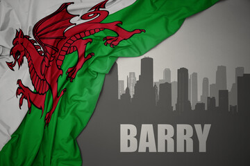 abstract silhouette of the city with text Barry near waving national flag of wales on a gray background.