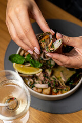 beautiful female hands with red manicure. Young girl holding oysters in her hands in an expensive restaurant. Seafood and Mediterranean cuisine with mussels