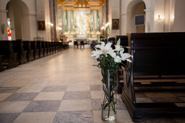 decor of flowers and a wooden bench in the Catholic Church