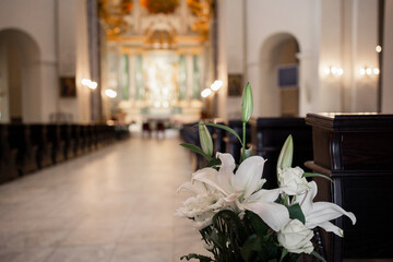 interior of a beautiful catholic church with benches icons and chandeliers