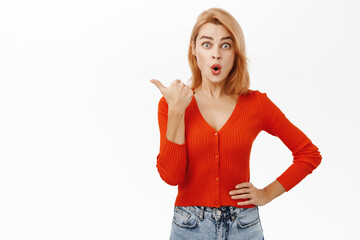 Enthusiastic girl smiling, pointing finger left, showing promo offer, way to store, banner or logo, standing over white background