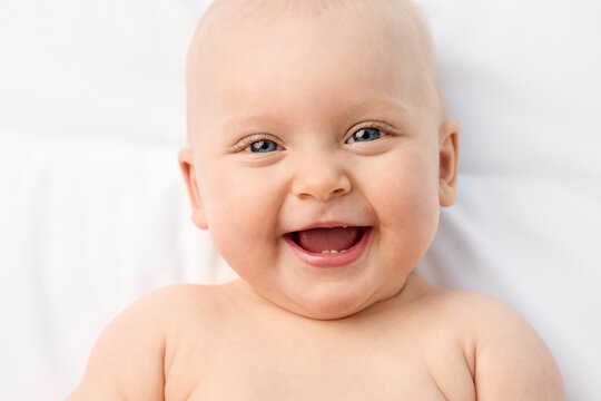 Close-up portrait of smiling blue-eyed baby girl