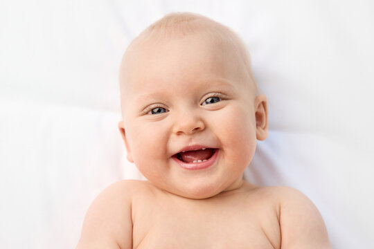 Close-up portrait of smiling blue-eyed baby