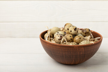 Quail eggs in a bowl on a white texture background. Natural products. Place for text. fresh eggs