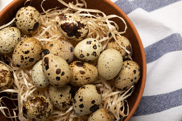Obraz premium Quail eggs in a bowl on a white texture background. Natural products. Place for text. fresh eggs
