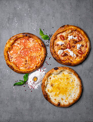 three delicious pizza on concrete, top view