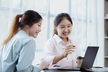 Beautiful Asian woman chatting with colleague in company office, businesswoman operating company administration, staff working as a team in department for planning meeting. Working women concept.