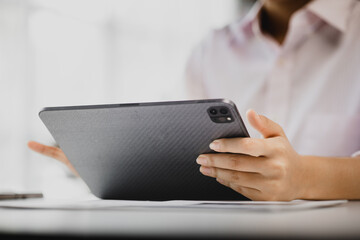young businesswoman looking at financial information from a tablet, she is checking company financial documents, she is a female executive of a startup company. Concept of financial management.