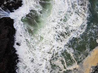 Top view of the white foamy waves of the ocean, storm. The beauty and grandeur of pristine nature. Abstraction. Ecology, climate change, global warming. There are no people in the photo.