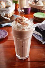 A glass of healthy fresh chocolate milkshake isolated on wooden background side view