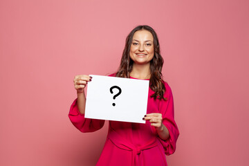 Woman holding question mark sign on pink background.