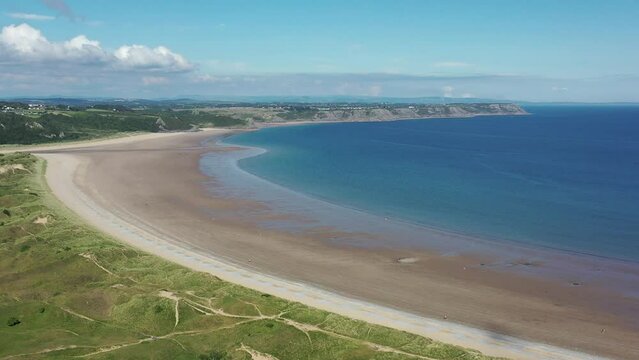 Oxwich Bay on the Gower peninsula in Swansea, UK, a long sweeping sandy bay with a shallow water line with easy access by road from Swansea attracts visitors from all over the UK