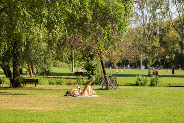 Woman sunbathing on the grass in a sunny Amsterdam Vondelpark in the Netherlands.