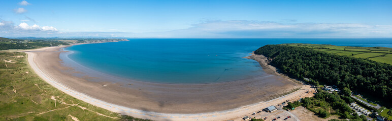 Oxwich Bay on the Gower peninsula in Swansea, UK, a long sweeping sandy bay with a shallow water...