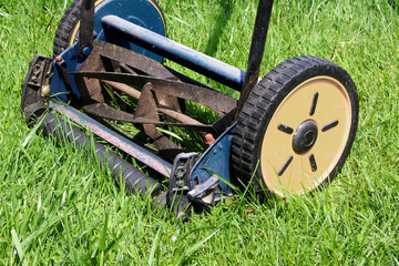 Obraz premium Push Lawn Mower side view on grassy lawn