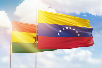 Sunny blue sky and flags of venezuela and ghana