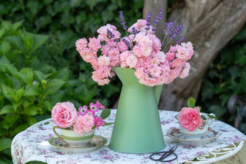 romantische Dekoration mit pink Rosenstrauß und vintage Kaffeetassen