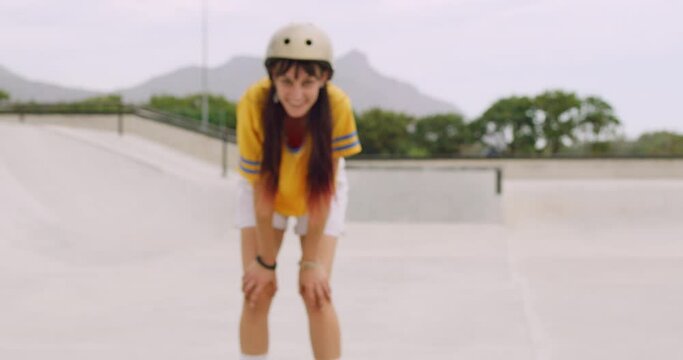 Cheerful woman skating in a roller rink outside. Portrait of trendy smiling female wearing safety helmet to practice fun rollerblading techniques and tricks. Face of carefree skater enjoying hobby