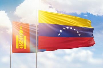 Sunny blue sky and flags of venezuela and mongolia