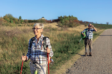 Active old woman and man walking at field and enjoy