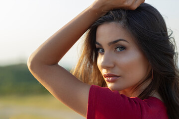 Fototapeta premium Portrait of beautiful woman in red standing on the road