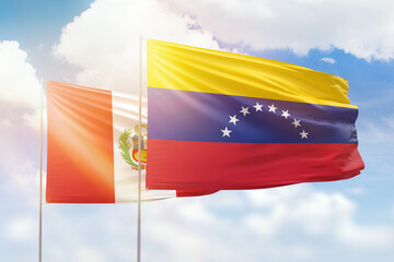 Sunny blue sky and flags of venezuela and peru