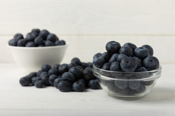 Blueberries in a bowl on a white textured background. Ripe and fresh blueberries. vitamins. Health food. Juicy berry. Copy space. Place for text