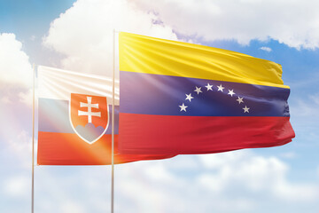 Sunny blue sky and flags of venezuela and slovakia