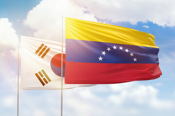 Sunny blue sky and flags of venezuela and south korea