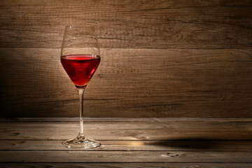 Red wine glass on wooden background