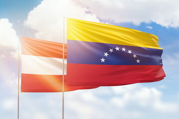 Sunny blue sky and flags of venezuela and austria