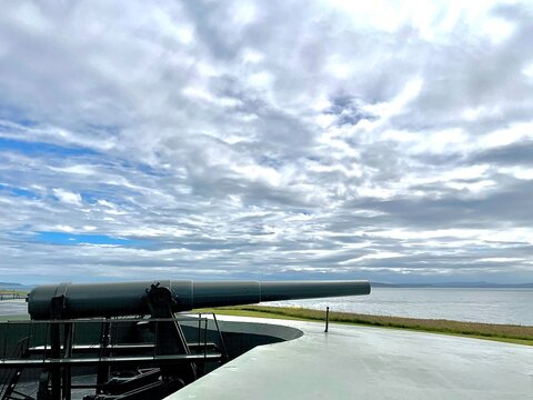 Military gun on a bunker with blue sky and clouds