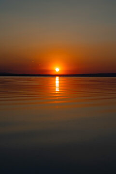 Sunset over the lake. Sunset or sunrise background photo.